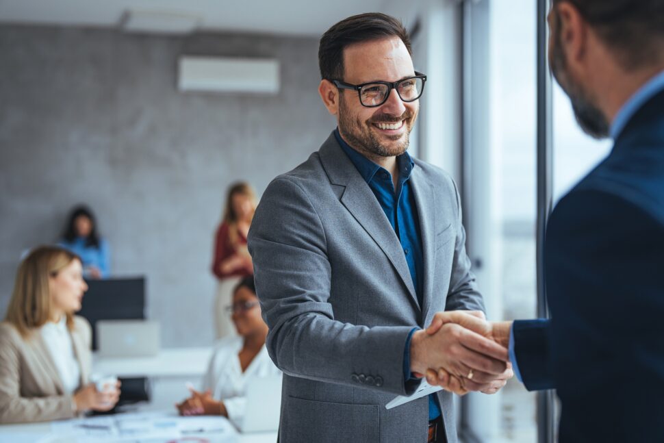 Businessmen shaking hands in office setting