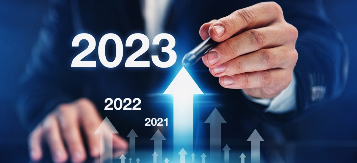 Person in suit pointing at rising 2023 arrow