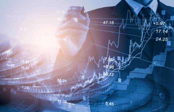 Hand holding pen over financial stock graph