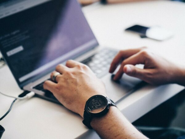 Hands typing on laptop at desk